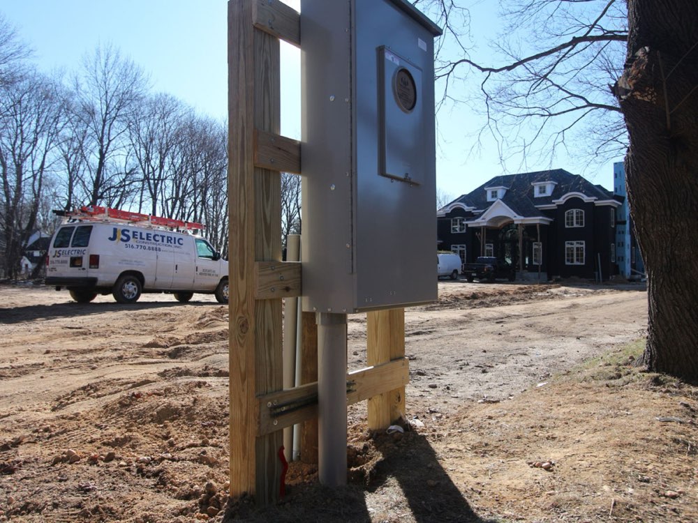 JS Electric branded van parked in front of a new-construction home